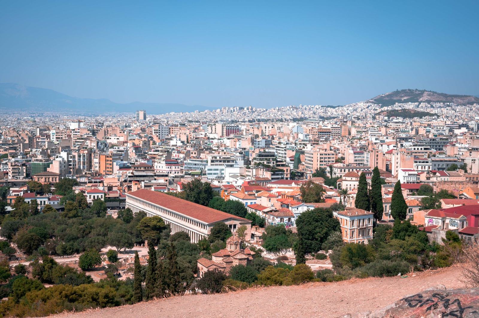Στέγες της Αθήνας και η Στοά του Αττάλου από λόφο, με το Λυκαβηττό στο βάθος