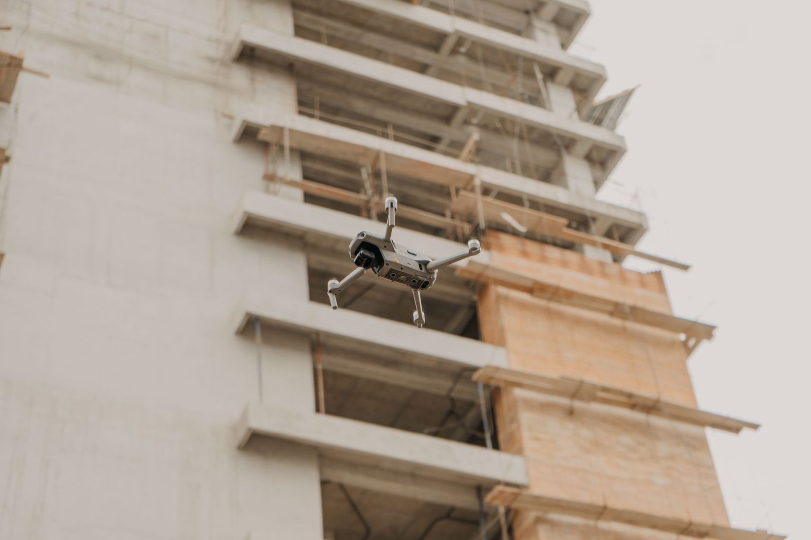 Drone σε αιώρηση δίπλα σε κτίριο από σκυρόδεμα υπό κατασκευή